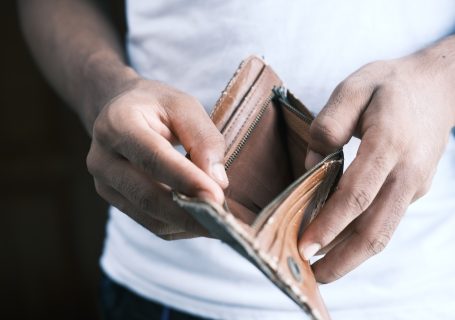 person holding brown leather bifold wallet